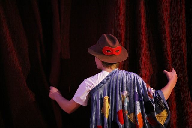 man on stage with curtain