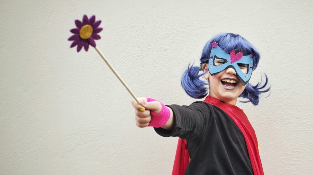 young girl imagining she is a superhero